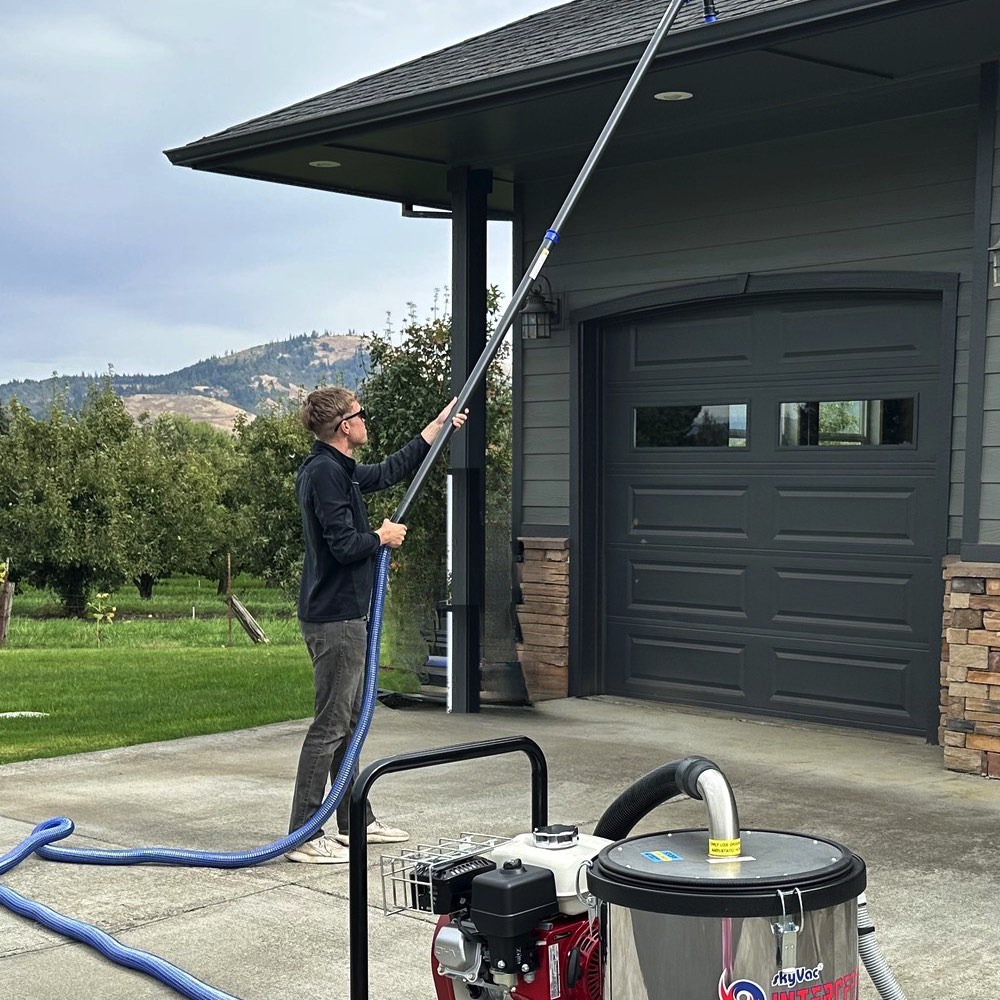 Ian Smith cleaning gutters from the ground with the vacuum